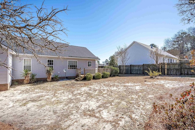 back of property with a deck and fence