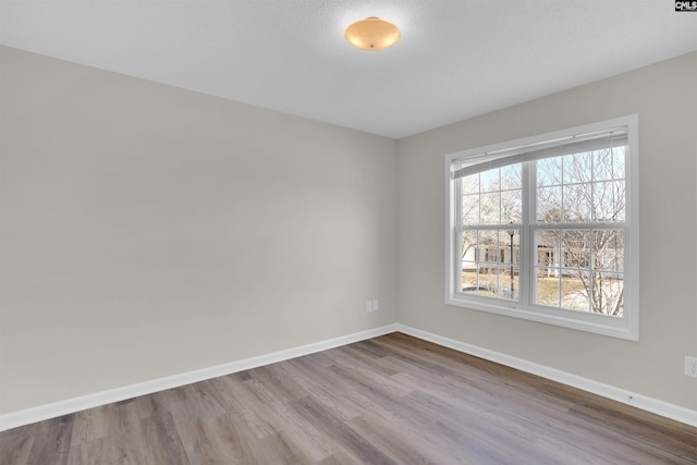 empty room with wood finished floors and baseboards