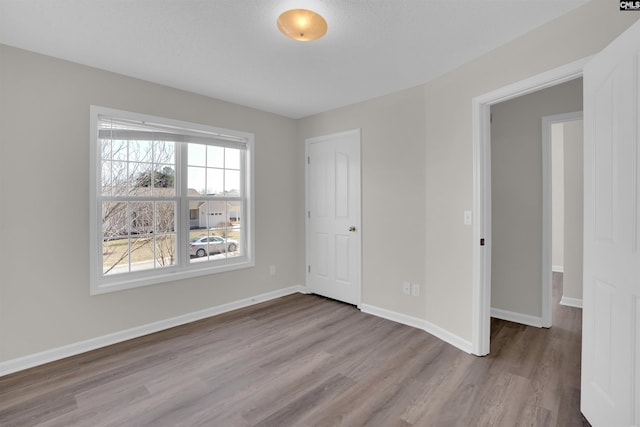 unfurnished room with baseboards and wood finished floors