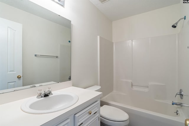 full bath featuring vanity, toilet,  shower combination, and a textured ceiling