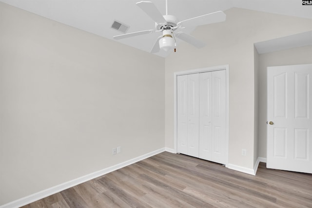 unfurnished bedroom featuring visible vents, baseboards, a closet, and wood finished floors