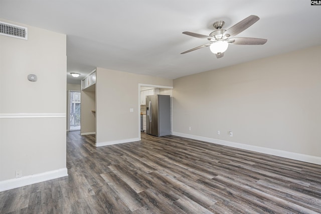 unfurnished living room with ceiling fan, visible vents, dark wood-style flooring, and baseboards