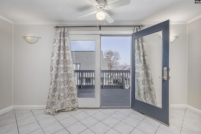 doorway with tile patterned flooring, ceiling fan, crown molding, and baseboards