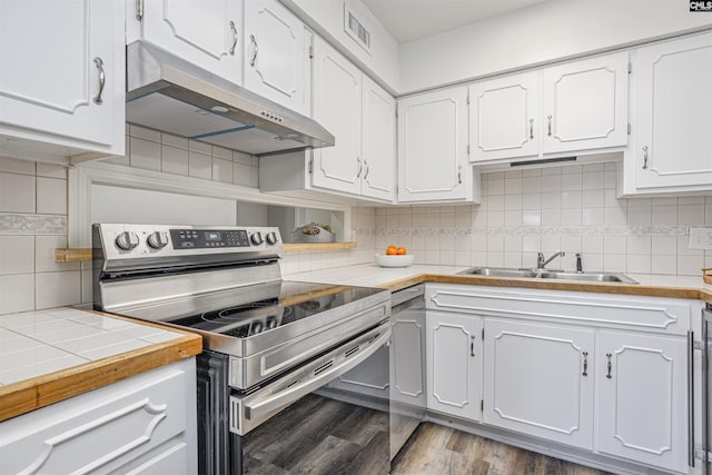 kitchen with visible vents, under cabinet range hood, electric range, white cabinets, and a sink