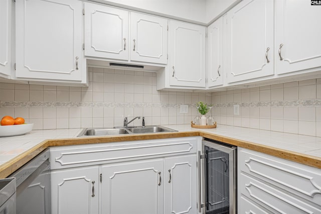 kitchen featuring a sink, backsplash, wine cooler, white cabinets, and dishwasher