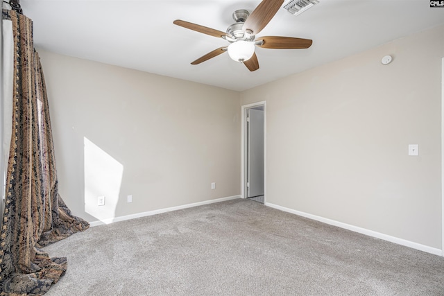 spare room featuring a ceiling fan, carpet, visible vents, and baseboards