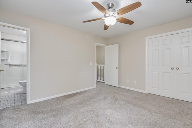 unfurnished bedroom with ensuite bath, a closet, baseboards, and carpet floors