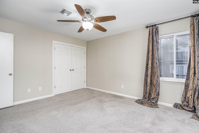 unfurnished bedroom with baseboards, visible vents, ceiling fan, a closet, and carpet flooring