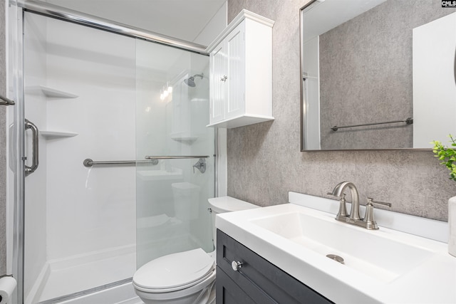 bathroom featuring a shower stall, toilet, and vanity