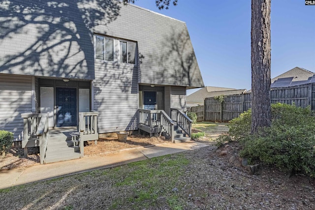 view of front of home featuring a shingled roof and fence