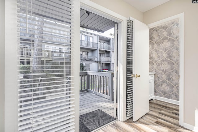 doorway to outside featuring plenty of natural light, baseboards, and wood finished floors