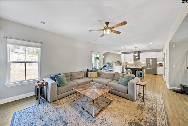 living room with visible vents, baseboards, recessed lighting, ceiling fan, and light wood-type flooring