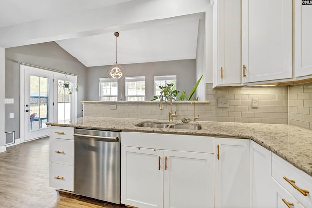 kitchen with lofted ceiling, a sink, white cabinets, dishwasher, and tasteful backsplash