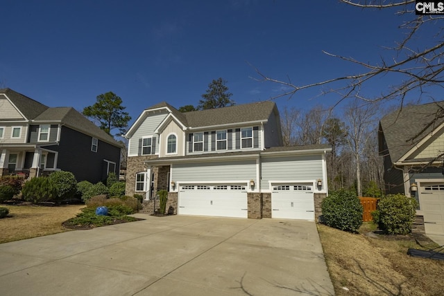 view of front of home featuring a garage, stone siding, and driveway