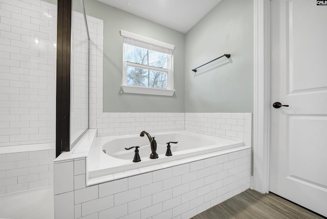 full bathroom featuring a bath and wood finished floors