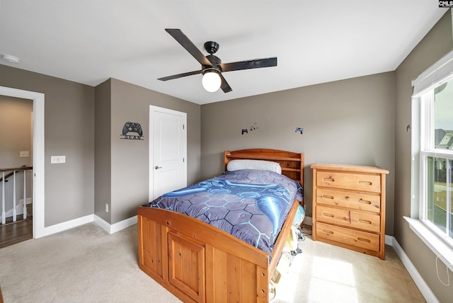 bedroom featuring a ceiling fan, light colored carpet, and baseboards