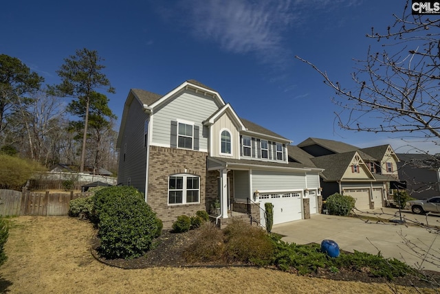 view of front of house with brick siding, concrete driveway, and fence