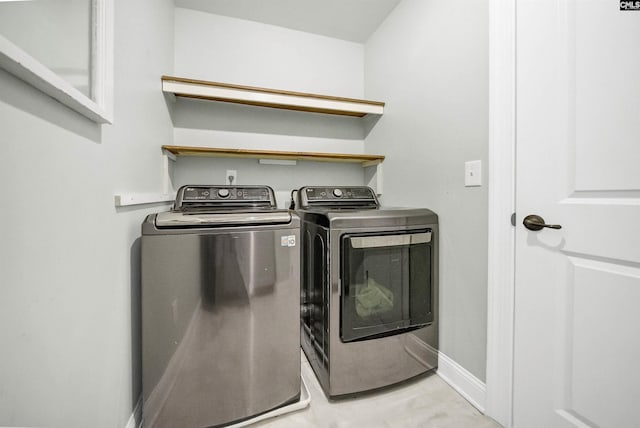 laundry room with baseboards, separate washer and dryer, and laundry area