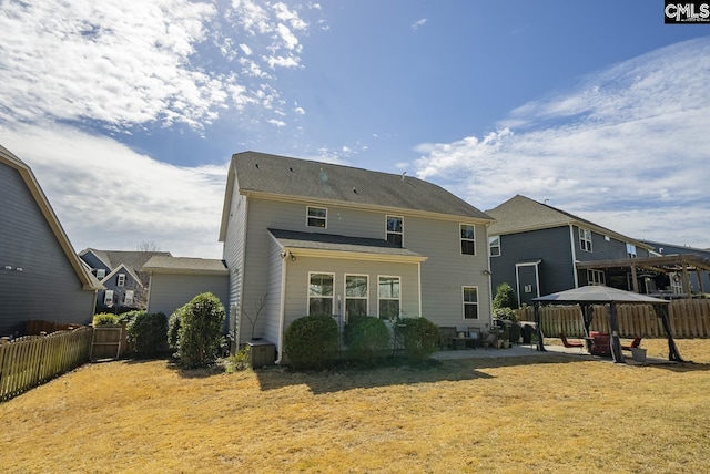 back of property featuring a gazebo, a lawn, a patio, and fence