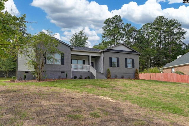 view of front of house featuring fence, covered porch, a front lawn, crawl space, and brick siding