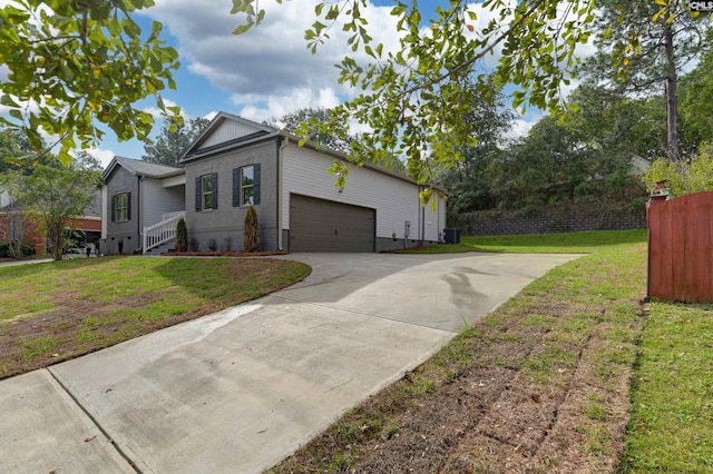 view of side of home featuring a yard, an attached garage, driveway, and fence