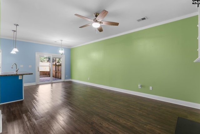 unfurnished living room featuring visible vents, a sink, dark wood finished floors, crown molding, and baseboards