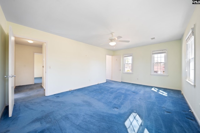 carpeted spare room featuring a ceiling fan and baseboards