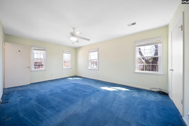 unfurnished room with baseboards, carpet, visible vents, and ceiling fan