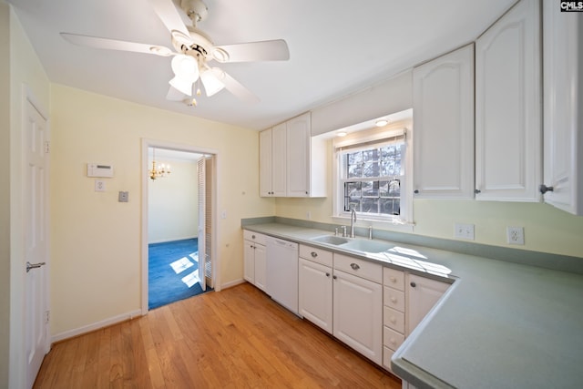 kitchen with dishwasher, light countertops, light wood-type flooring, white cabinets, and a sink