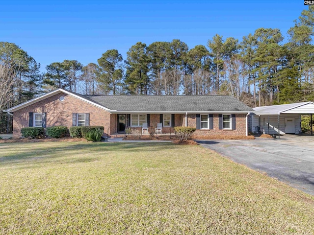 ranch-style house featuring a detached garage, brick siding, a porch, and a front lawn