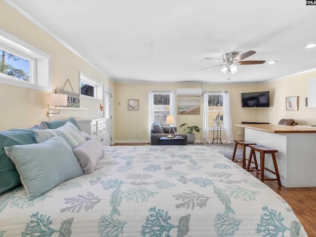 bedroom with multiple windows, crown molding, and wood finished floors