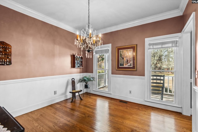 interior space featuring visible vents, a wainscoted wall, wood finished floors, and crown molding