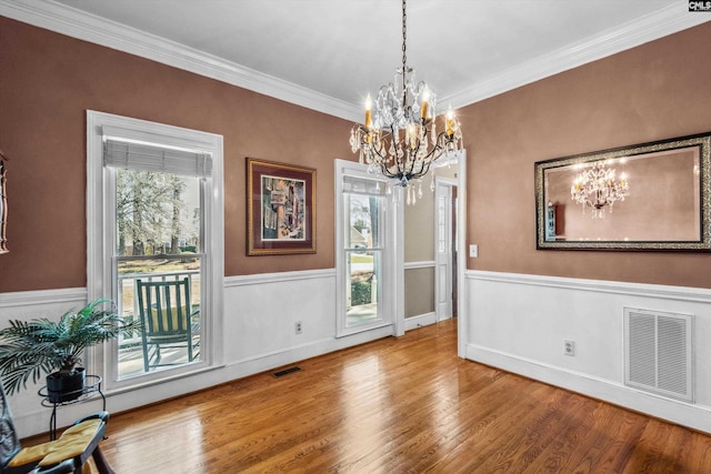 dining room with visible vents, crown molding, and wood finished floors