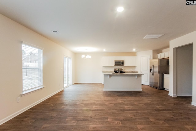 kitchen featuring visible vents, dark wood-style floors, white cabinetry, stainless steel appliances, and an inviting chandelier