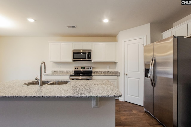 kitchen with a sink, appliances with stainless steel finishes, and white cabinets