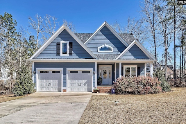 view of front facade with a porch, concrete driveway, a garage, and roof with shingles