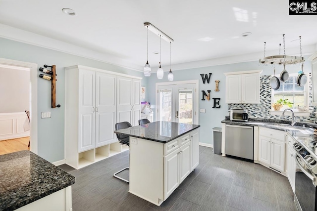 kitchen with tasteful backsplash, a kitchen island, a breakfast bar, appliances with stainless steel finishes, and a sink