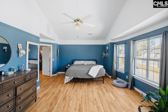 bedroom featuring a ceiling fan, visible vents, baseboards, high vaulted ceiling, and light wood-style floors