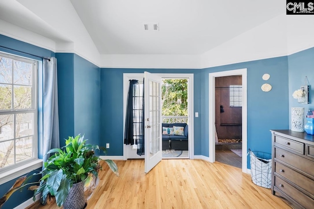 interior space with a wealth of natural light, light wood-style flooring, and lofted ceiling