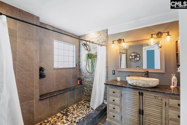 bathroom with vanity and tiled shower