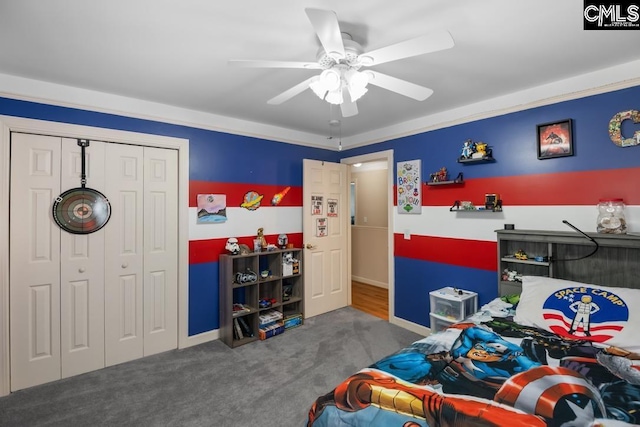 carpeted bedroom with a closet, baseboards, and ceiling fan