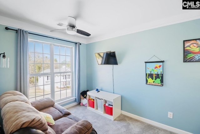 living area featuring a healthy amount of sunlight, baseboards, carpet floors, and ceiling fan