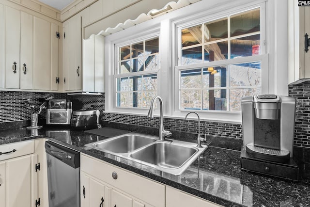 kitchen with tasteful backsplash, a sink, white cabinetry, and stainless steel dishwasher