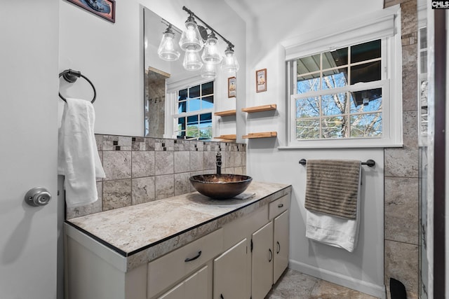 bathroom with decorative backsplash, vanity, and baseboards