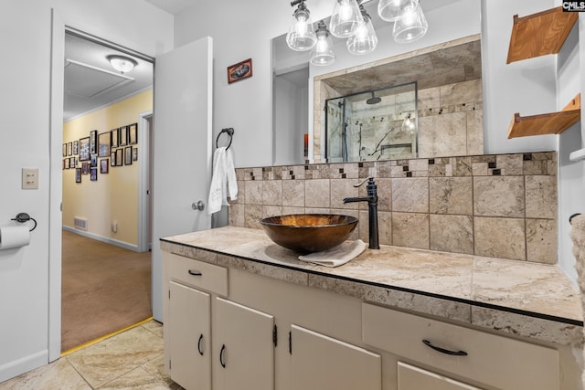 bathroom featuring vanity, baseboards, visible vents, a tile shower, and tasteful backsplash