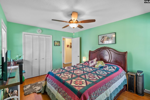 bedroom with a closet, baseboards, ceiling fan, and wood finished floors