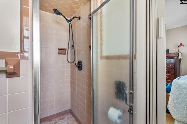 bathroom featuring a shower stall and connected bathroom