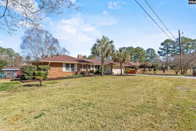 exterior space with a front lawn, an attached garage, and brick siding