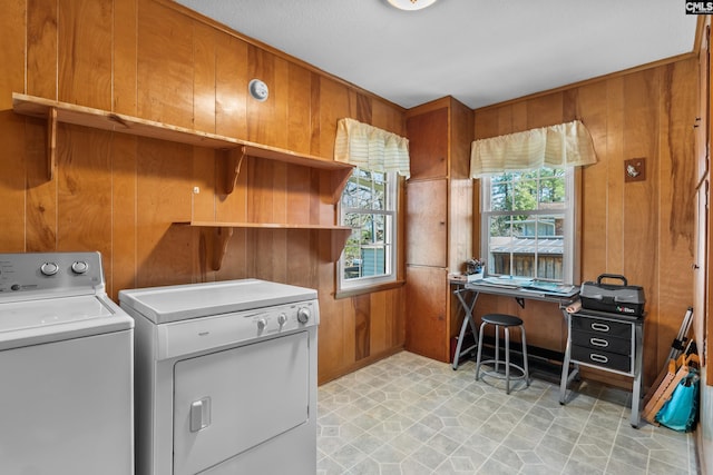 washroom with wooden walls, light floors, laundry area, and washing machine and clothes dryer