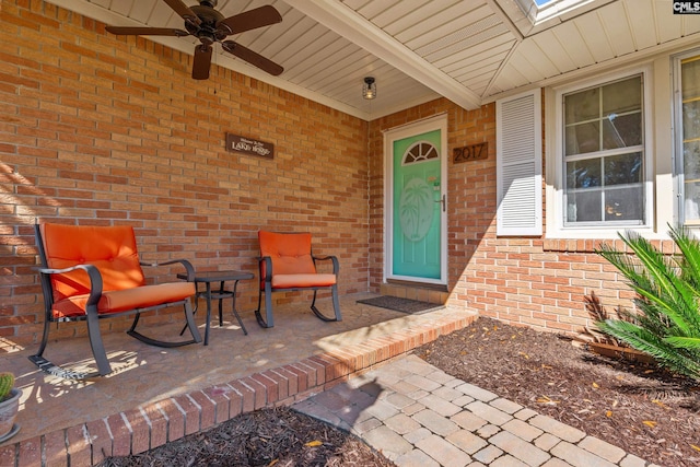 doorway to property with brick siding and ceiling fan